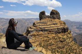 Waqra Pukara Photos - Panoramic photo of Waqra Pukara with a tourist sitting, contemplating the mountain